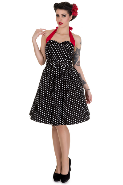 Model wearing halterneck dress in black and white polka dots