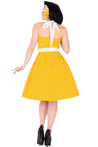 Model wearing halterneck retro dress in yellow polka dot print back view