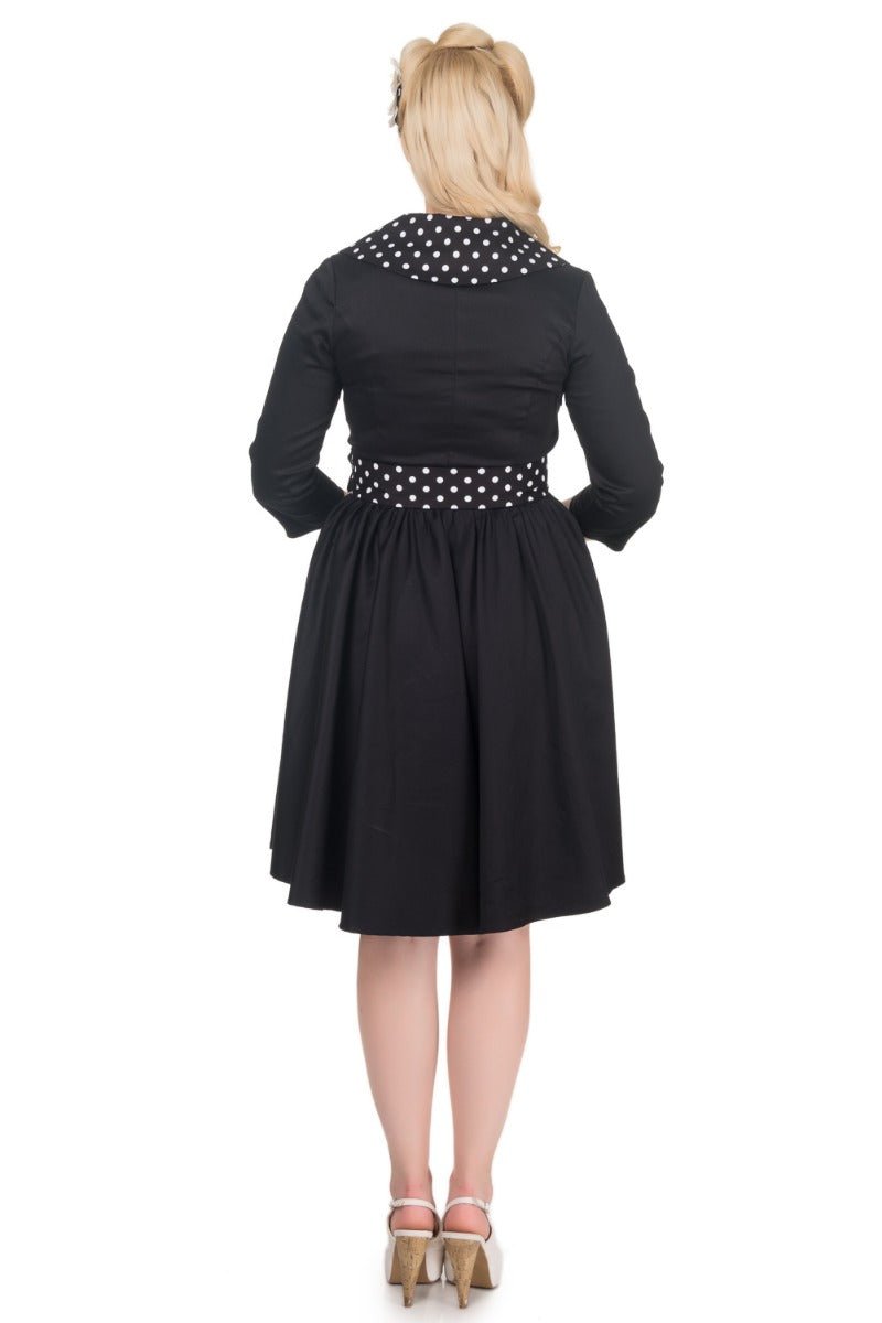 Model wearing black white polka dot collared swing dress back