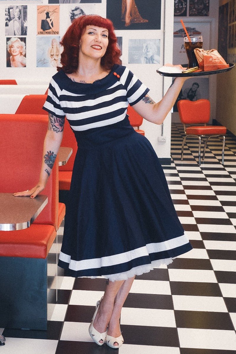 Influencer wearing navy blue/white striped vintage dress with white petticoat in American diner
