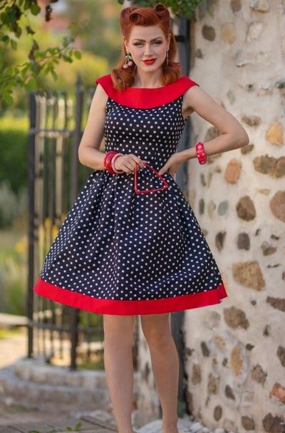 Model wearing black, red and white polka dot swing dress