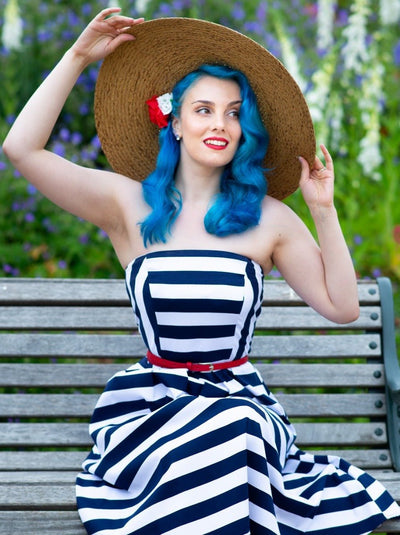 Customer in strapless bandeau white blue striped dress and large hat